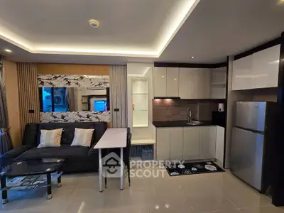 Modern open-layout living room and kitchen with sleek design and stylish furniture.