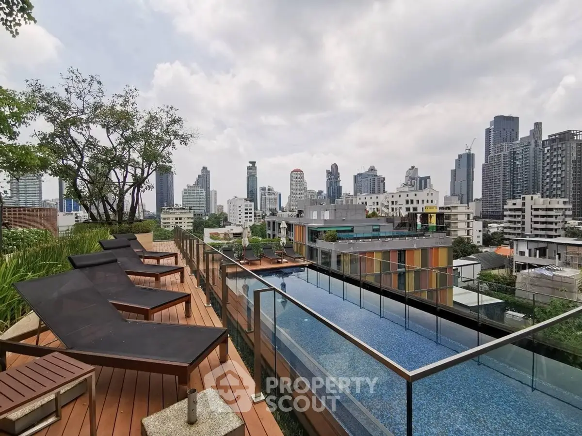 Luxurious rooftop pool with stunning city skyline view and modern lounge chairs.