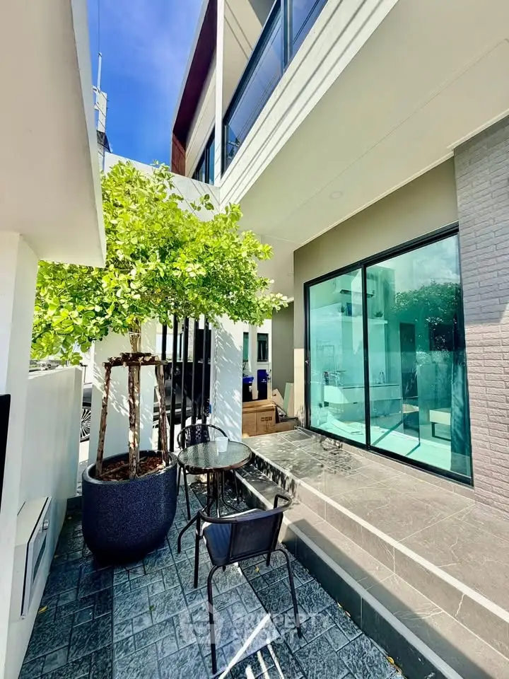 Modern home exterior with stylish patio and large glass doors, perfect for outdoor relaxation.
