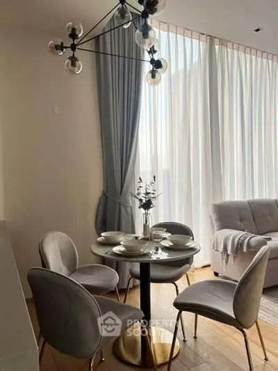 Stylish dining area with modern chandelier and elegant curtains in a cozy living space.