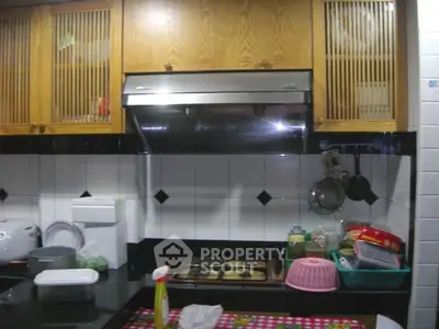 Cozy kitchen with gas stove and wooden cabinets, perfect for home cooking enthusiasts.