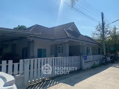 Charming single-story house with tiled roof and fenced yard in a serene neighborhood.