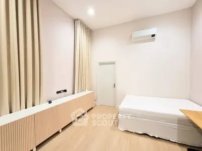 Spacious bedroom with minimalist decor, featuring a comfortable bed and elegant curtains, perfect for relaxation.