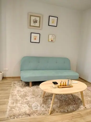 Cozy and modern living space featuring a stylish teal sofa, chic wooden coffee table, and elegant wall art, perfect for relaxation.