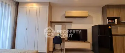 Modern studio apartment with stylish furniture and built-in storage solutions.