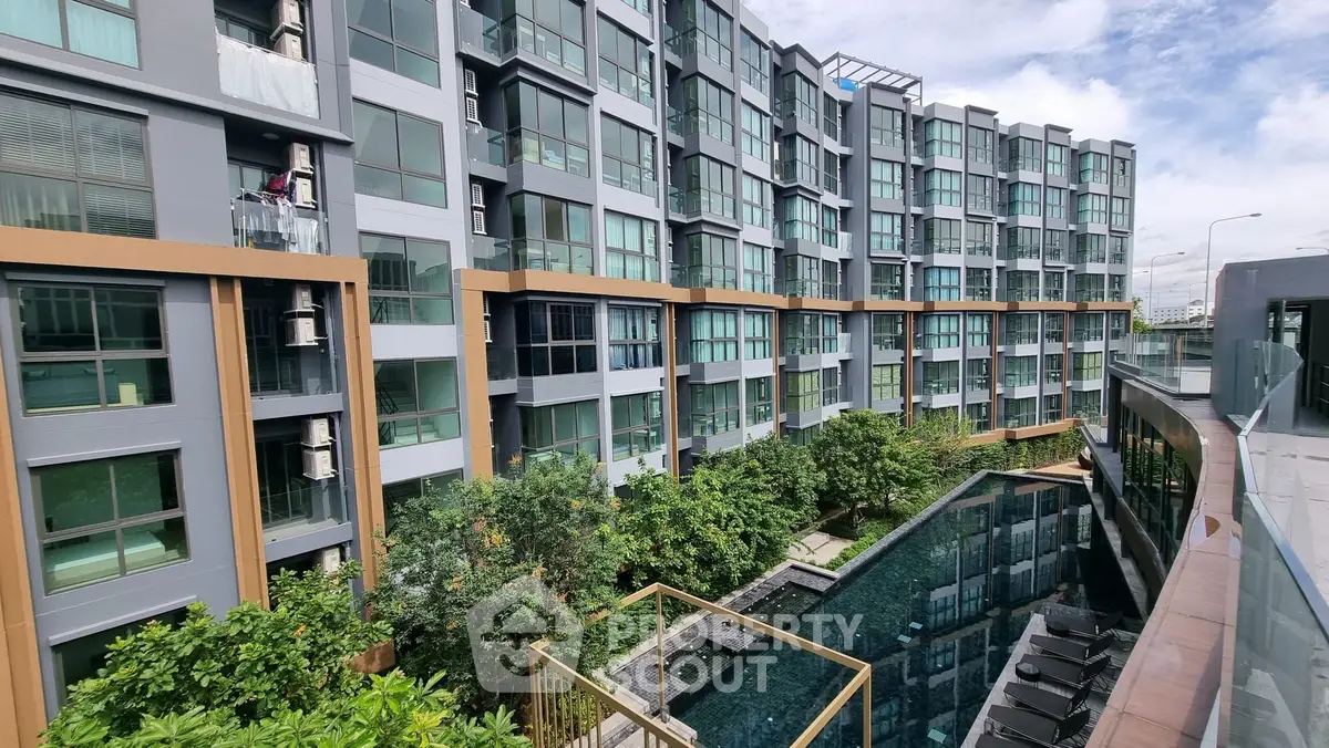 Modern condominium with pool view and lush greenery