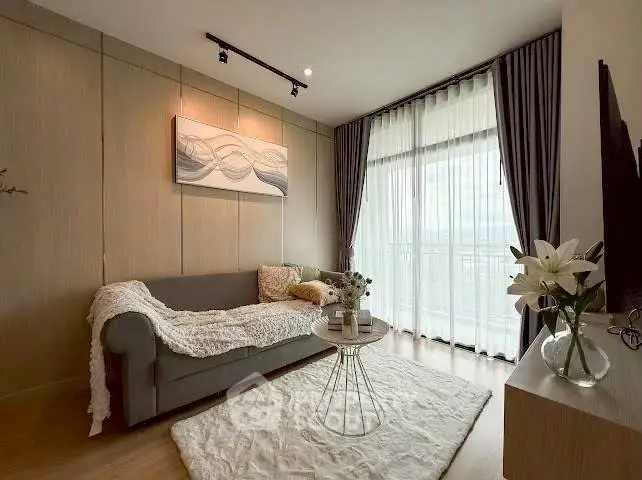 Elegant living room with cozy sofa, stylish decor, and large window offering natural light and scenic views.