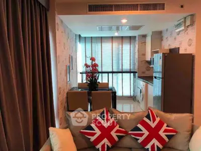 Stylish modern living room with British-themed decor and open kitchen layout.