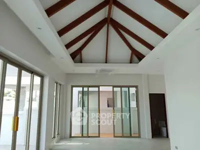 Spacious modern living room with high vaulted ceiling and large sliding glass doors.