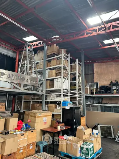 Spacious industrial warehouse with high ceilings and organized shelving units for efficient storage.