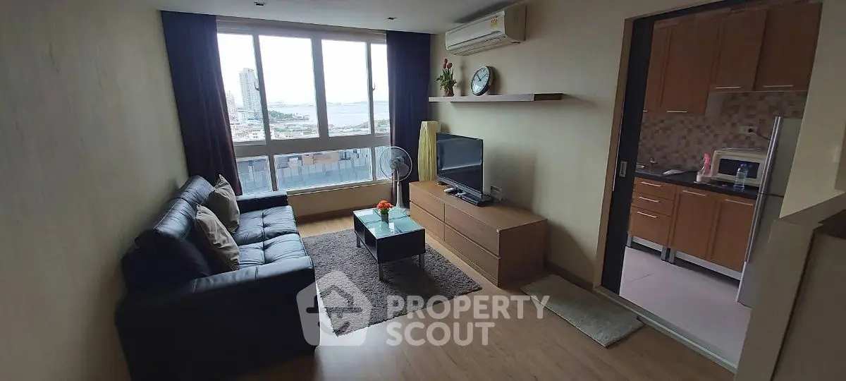 Modern living room with city view and adjacent kitchen in high-rise apartment