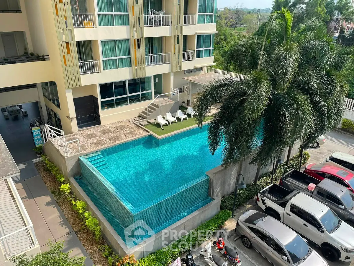 Luxurious apartment building with stunning infinity pool and lush palm trees, perfect for resort-style living.