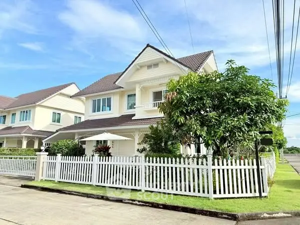 Charming suburban home with white picket fence and lush greenery