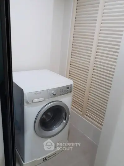 Compact laundry area with modern washing machine in a cozy corner