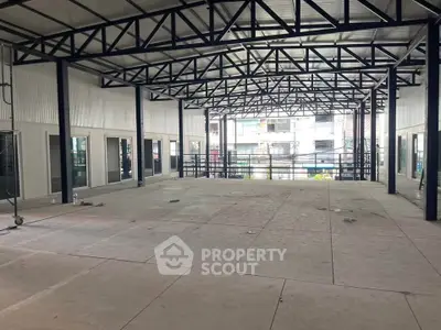 Spacious industrial-style open space with high ceilings and metal beams