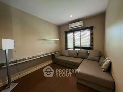 Cozy living room with modern sofa and air conditioning, perfect for relaxation.