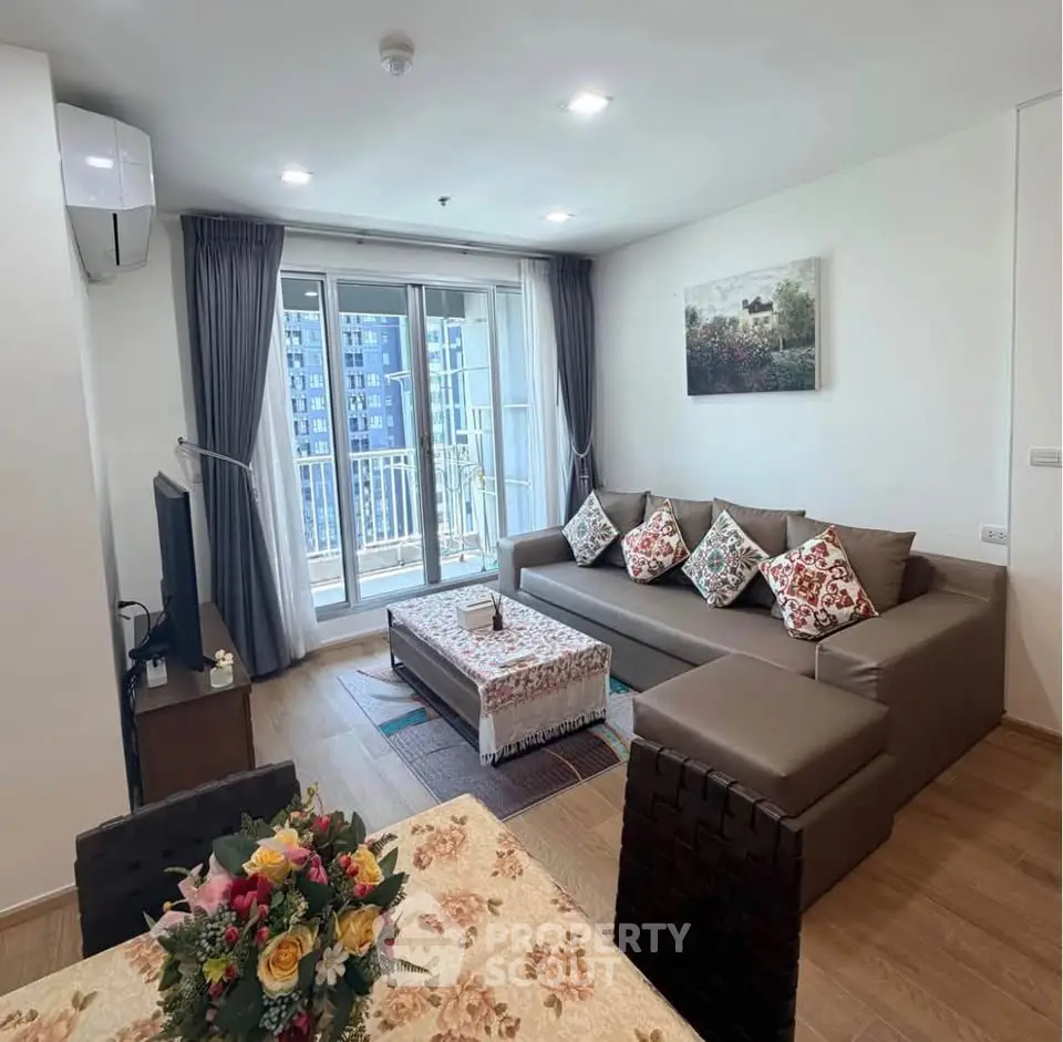 Spacious modern living room with large sofa and balcony view in a stylish apartment.