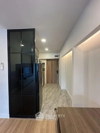 Modern kitchen with sleek black fridge and stylish wooden accents