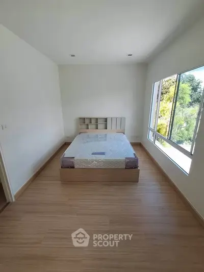 Spacious bedroom with large window and minimalist design