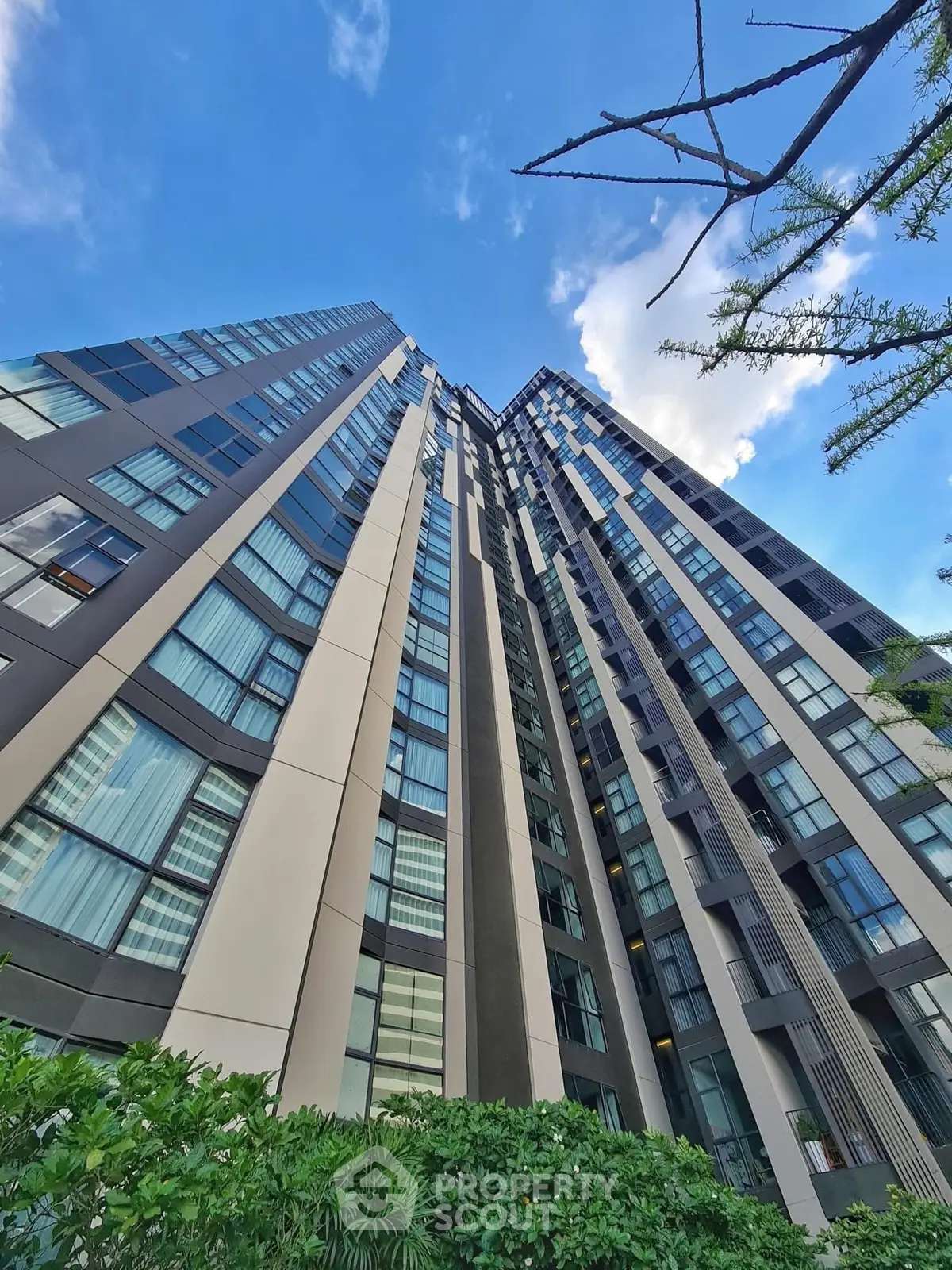 Stunning modern high-rise building with sleek architecture and lush greenery, perfect for urban living.
