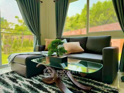 Chic living room with modern sofa, glass coffee table, and lush garden view.