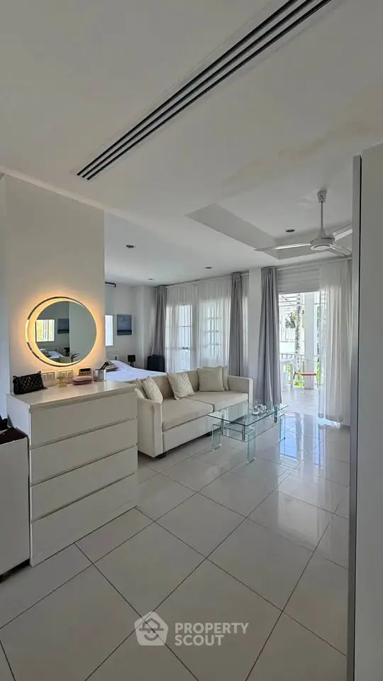 Spacious living room with modern decor and natural light in a stylish apartment.