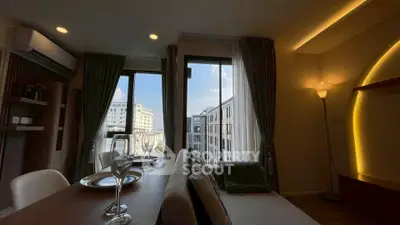 Modern living room with elegant decor and city view through large windows.