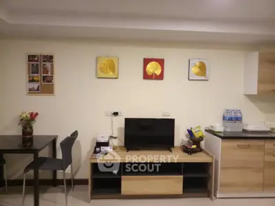 Modern living room with stylish decor and compact kitchen area, perfect for cozy urban living.