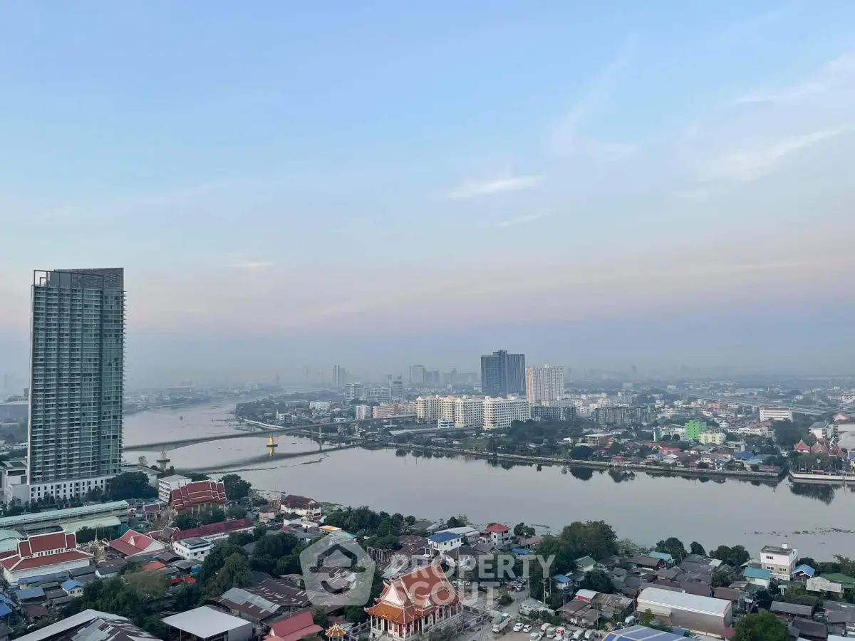 Stunning cityscape view with river and high-rise buildings at sunset.