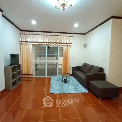 Spacious living room with modern furniture and large window for natural light.