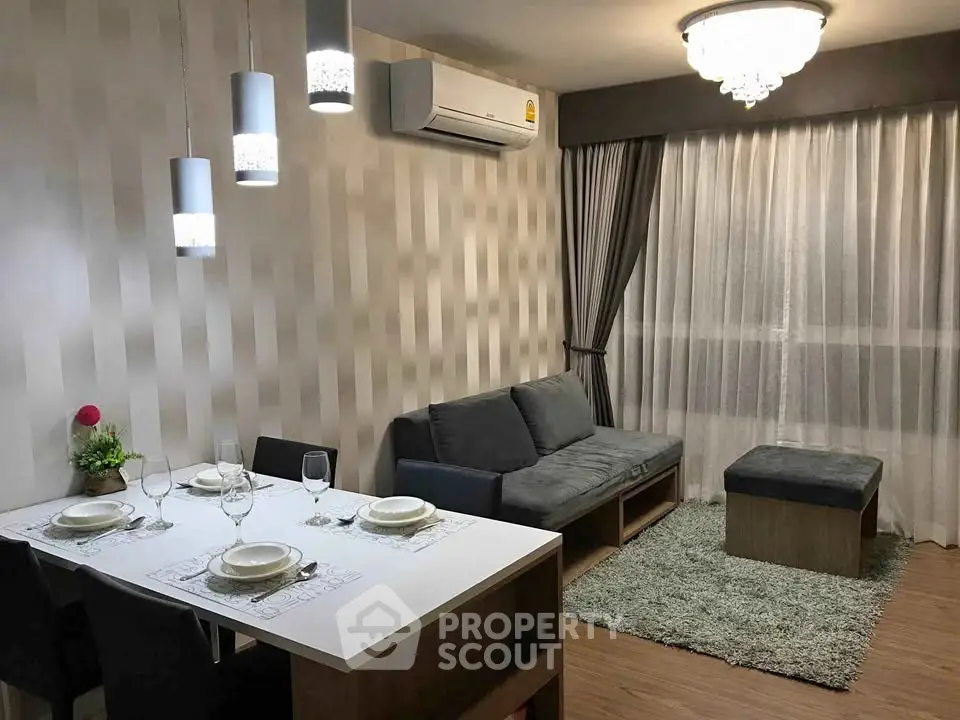 Modern living room with elegant dining area and cozy seating, featuring stylish lighting and air conditioning.