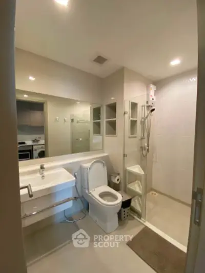 Modern bathroom with glass shower and sleek fixtures in a contemporary apartment.