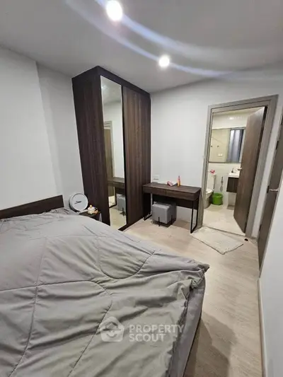 Modern bedroom with sleek design, featuring a cozy bed, mirrored wardrobe, and ensuite bathroom for ultimate comfort.