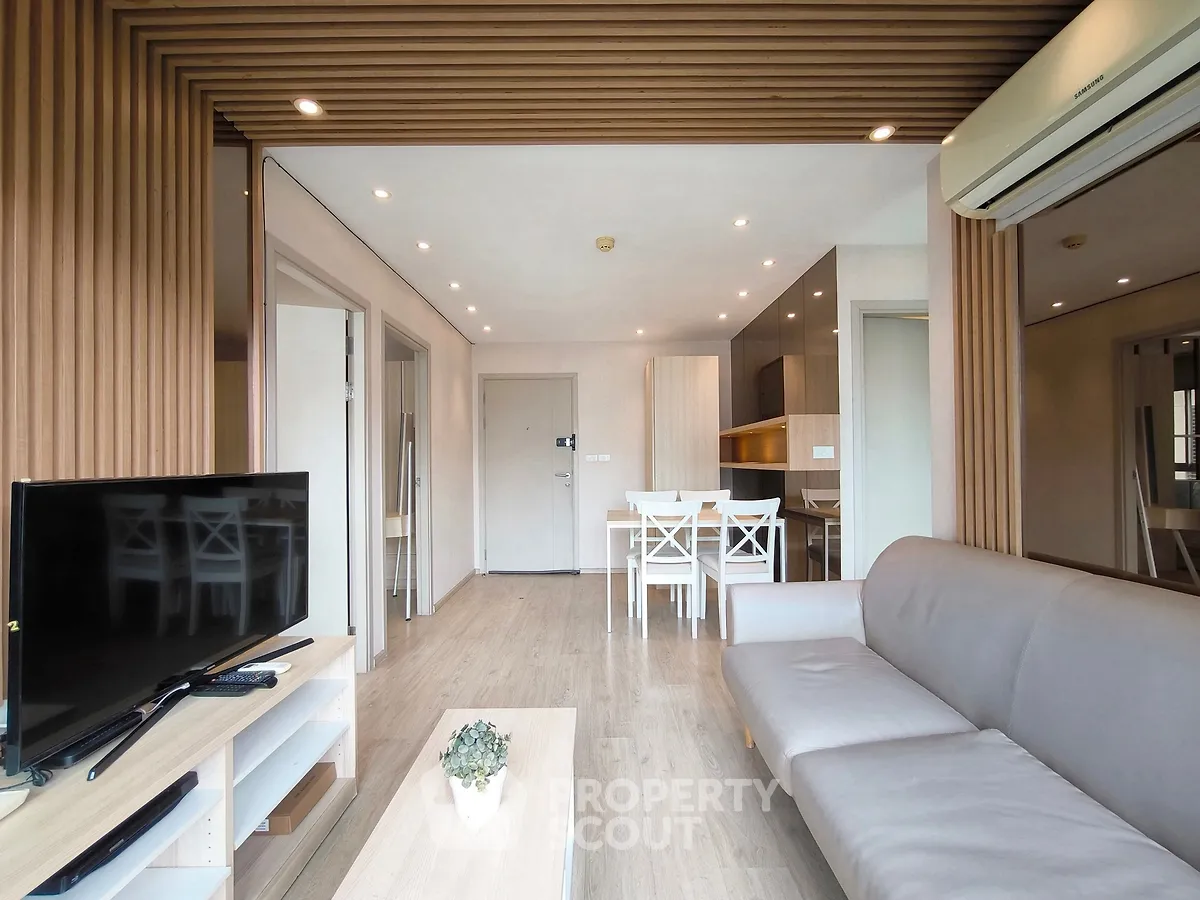 Modern living room with sleek furniture and open layout, featuring a cozy dining area and stylish decor.