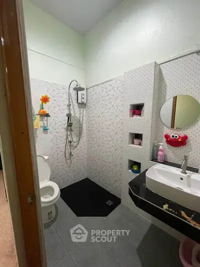 Charming bathroom with modern shower and playful decor, perfect for a cozy home.