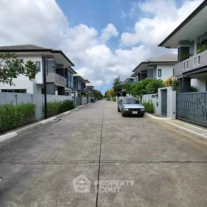 Charming suburban street with modern homes and clear blue skies, perfect for family living.