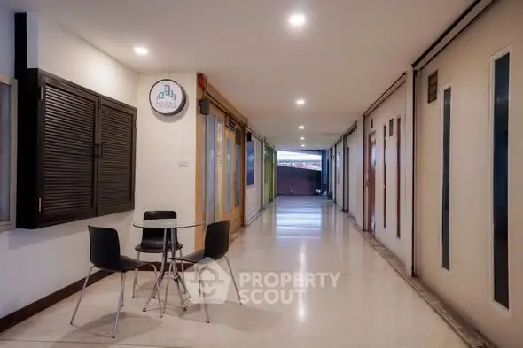 Modern corridor with sleek design and seating area in a contemporary building.