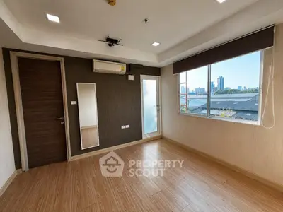 Spacious empty room with large window and city view, perfect for customization.