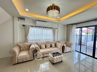 Luxurious living room with elegant chandelier and plush seating, featuring large windows for natural light.