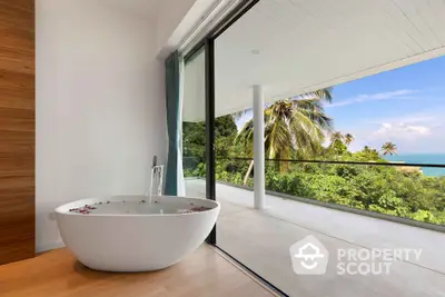 Luxurious bathroom with freestanding tub and stunning tropical balcony view