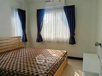 Cozy bedroom with natural light, featuring a wooden bed frame and elegant curtains.