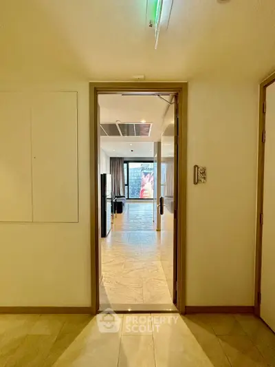 Spacious modern apartment entrance with open view to living area and large windows.