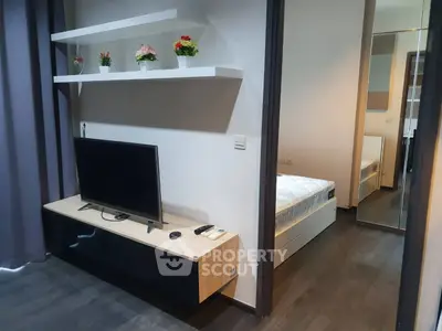 Modern apartment interior with TV unit and bedroom view