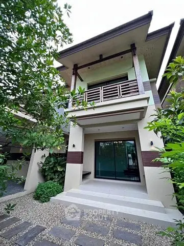 Modern two-story house with lush greenery and elegant facade