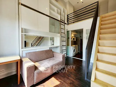 Modern loft apartment with mezzanine, cozy sofa, and washing machine in bright interior.