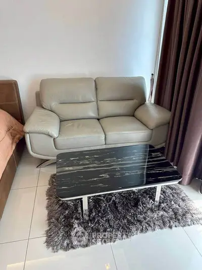 Modern living room with sleek leather sofa and stylish marble coffee table on plush rug.