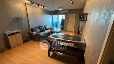 Spacious living room with modern decor and large windows in a stylish apartment.