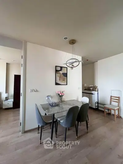 Modern dining area with elegant decor and wooden flooring in a stylish apartment.