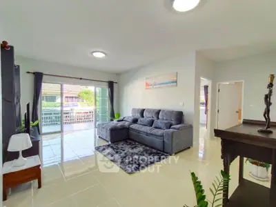 Spacious living room with modern decor and large sliding glass doors to balcony.