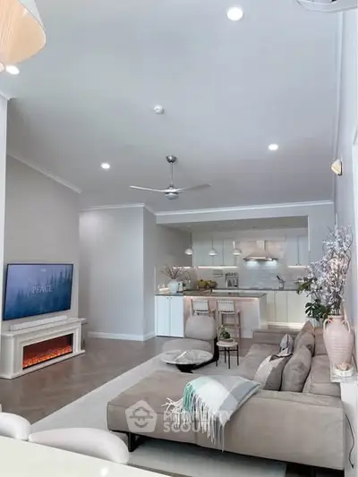 Modern living room with open kitchen, stylish decor, and cozy ambiance.